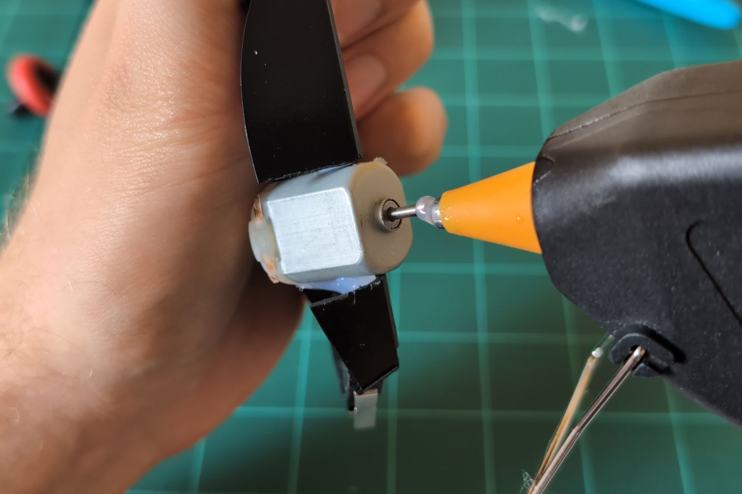 Adding hot glue to the end of the motor shaft.